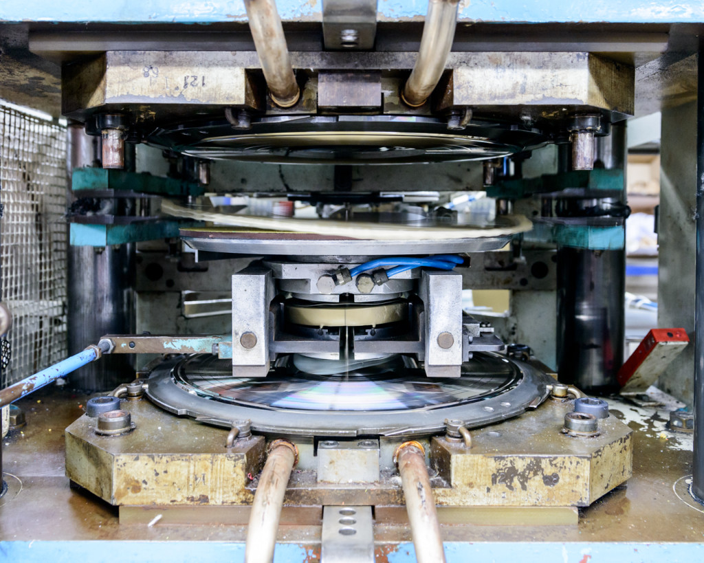 The record being pressed: the gold puck in the middle will be pressed against the negatives at the top and bottom to make the record - this will be a gold record